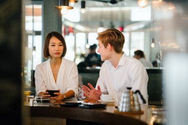 farklı çift (tek bir beyaz adam, diğer bir Çinli kadın) bir kafede kahve üzerine bir tartışma var. Onlar kendi fincan kahve tadını çıkarıyor ve animatedly sohbet.