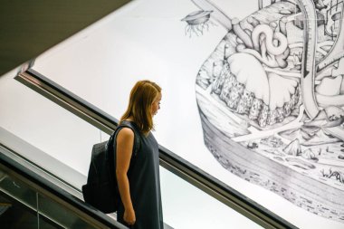 yürüyen merdiven Singapur kullanan kadın.