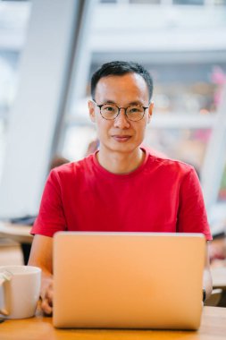 laptop bir kafede Asya Orta yaşlı adam (Çince veya Japonca) çalışma.