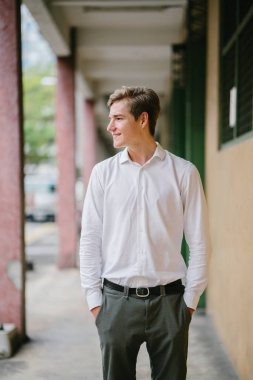 Stüdyo portre gülümseyen genç bir beyaz adam. İş rahat giyiniyor. O genç, yakışıklı, fotojenik ve mutlu, kendine güvenen ve heyecanlı görünüyor.