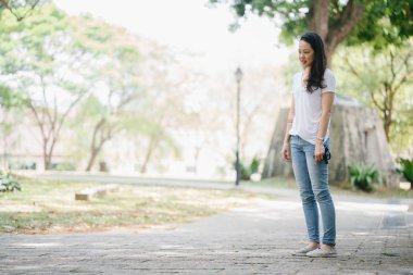 Onun genç shih tzuh yavru köpek park ile gün içinde oturan genç Pan Asya kadın portresi. Gülümsüyor ve her ikisi de sıcak gün tadını çıkarıyor.