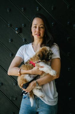 Genç bir kız ve köpeği portresi. Pan Asya kadın çekici ve raslantı giyimli ve onun Shih Tzuh onun kollarında taşıyor ve yumuşak gülümsüyor.