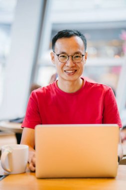 laptop bir kafede Asya Orta yaşlı adam (Çince veya Japonca) çalışma.