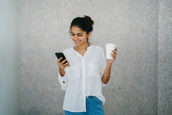迷人的年轻印度亚裔妇女微笑着一杯咖啡和电话 — 图库照片