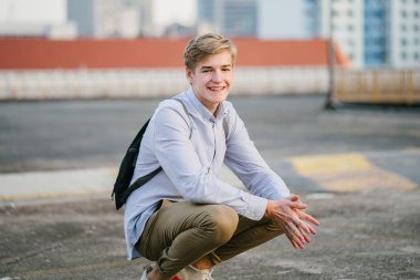 genç ve çekici beyaz bir portresi beyaz adam (turist veya öğrenci) gündoğumu veya günbatımı Asya'da gülümseyerek. O gülümsüyor ve rahat.