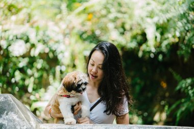 Parkta onun shih tzuh köpek olan bir genç, çekici pan Asya kadın portresi. Onlar ortasında bir yürüyüş ve neşeli ve rahat görünüyorlar.