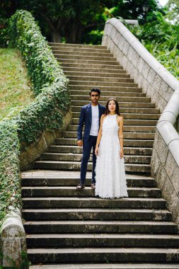 gün boyunca parkta taş basamaklar üzerinde Interracial aşıklar çifti. Bir Hintli bir Çinli kadın zevk ve neşe içinde evleniyor.