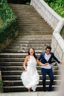 gün boyunca parkta taş basamaklar üzerinde Interracial aşıklar çifti. Bir Hintli bir Çinli kadın zevk ve neşe içinde evleniyor.