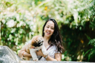 Parkta onun shih tzuh köpek olan bir genç, çekici pan Asya kadın portresi. Onlar ortasında bir yürüyüş ve neşeli ve rahat görünüyorlar.