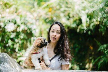 Parkta onun shih tzuh köpek olan bir genç, çekici pan Asya kadın portresi. Onlar ortasında bir yürüyüş ve neşeli ve rahat görünüyorlar.