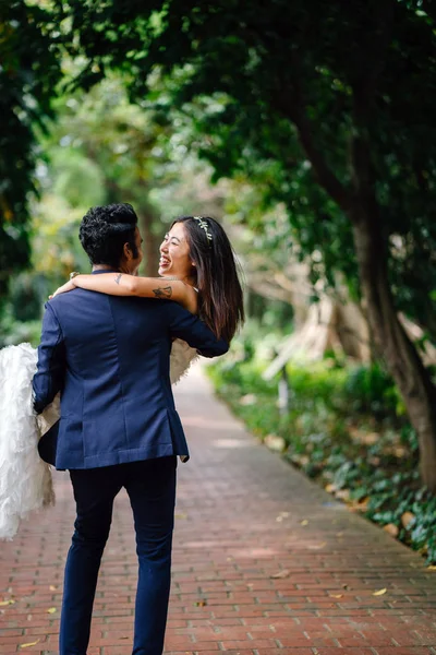 婚約中の異人種間カップルは従事しているし シンガポールの公園で結婚式の写真を取る 彼らは両方の喜びと楽しさで笑っているとインド人を運ぶと彼の中国の妻を回転 — ストック写真