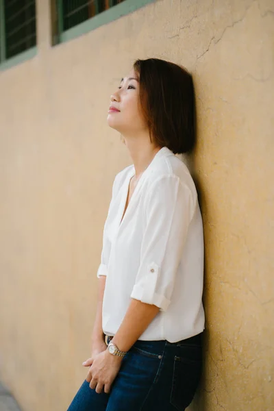 Portrait Attractive Chinese Asian Woman Leaning Pastel Yellow Wall Singapore — Stock Photo, Image