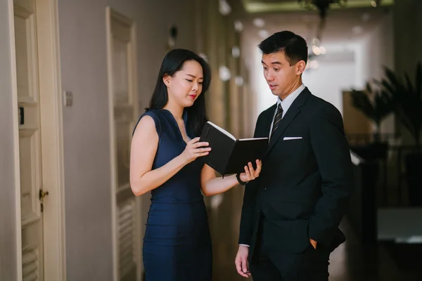 business people (a Chinese Asian man and woman) are having a meeting