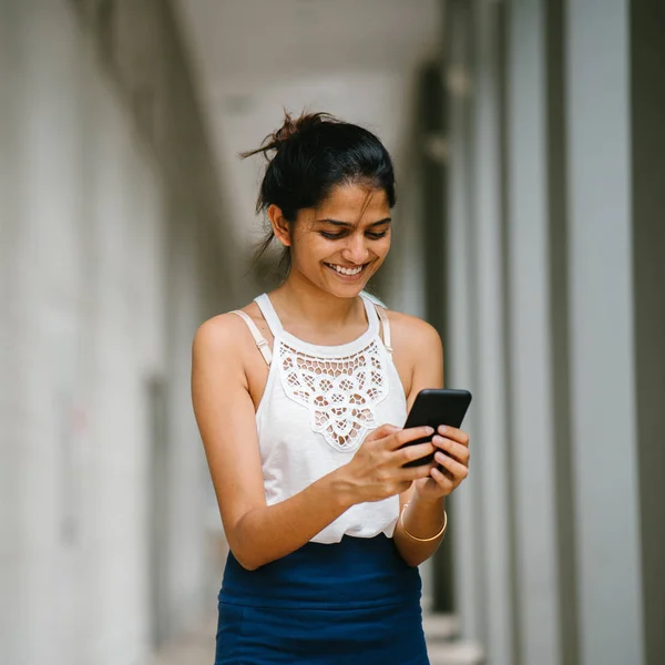 有吸引力和年轻的印度妇女的肖像 穿着专业 她站在一个智能手机 — 图库照片