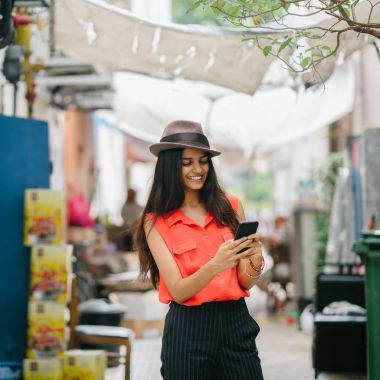 moda ve şık genç Hintli Asyalı kadın onun smartphone bir arka sokakta Asya'da günde konuşuyor. O gülümseyen ve yürüyor gibi konuşuyor.