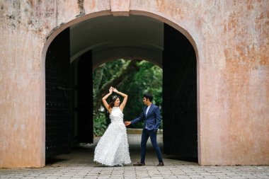  bir takım elbise dansları yakışıklı Hintli adam gün boyunca Asya'da bir parkta Çin onun nişanlısı ile. Irklararası çift yeni nişanlı ve alarak düğün fotoğrafları parkta olduğunu.