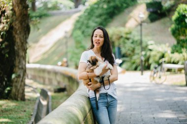 Parkta onun shih tzuh köpek olan bir genç, çekici pan Asya kadın portresi. Onlar ortasında bir yürüyüş ve neşeli ve rahat görünüyorlar.