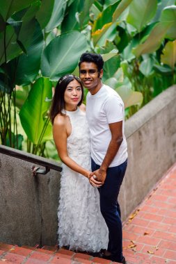 Genç, ırklararası çift çekim Fort Canning, Singapur'da sonra nişanlanmak portresi. Onlar gülüyor ve iskambil çevrede; mutlu ve heyecanlı onların geleceği ile ilgili.