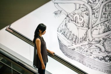 yürüyen merdiven Singapur kullanan kadın.