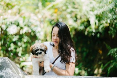 Parkta onun shih tzuh köpek olan bir genç, çekici pan Asya kadın portresi. Onlar ortasında bir yürüyüş ve neşeli ve rahat görünüyorlar.