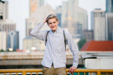 genç ve çekici beyaz bir portresi beyaz adam (turist veya öğrenci) gündoğumu veya günbatımı Asya'da gülümseyerek. O gülümsüyor ve rahat.