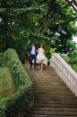 gün boyunca parkta taş basamaklar üzerinde Interracial aşıklar çifti. Bir Hintli Çinli bir kadını evleniyor ve onlar zevk ve neşe içinde merdivenlerden aşağı çalışan.