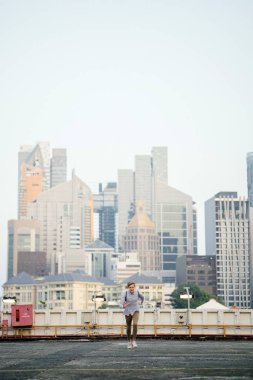 Asya araba parkında gün batımında kameraya Sprint bir genç ve yakışıklı beyaz genç dinamik portresi.