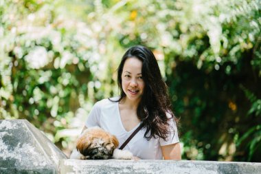 Parkta onun shih tzuh köpek olan bir genç, çekici pan Asya kadın portresi. Onlar ortasında bir yürüyüş ve neşeli ve rahat görünüyorlar.