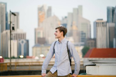 genç ve çekici beyaz bir portresi beyaz adam (turist veya öğrenci) gündoğumu veya günbatımı Asya'da gülümseyerek. O gülümsüyor ve rahat.