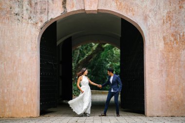  bir takım elbise dansları yakışıklı Hintli adam gün boyunca Asya'da bir parkta Çin onun nişanlısı ile. Irklararası çift yeni nişanlı ve alarak düğün fotoğrafları parkta olduğunu.