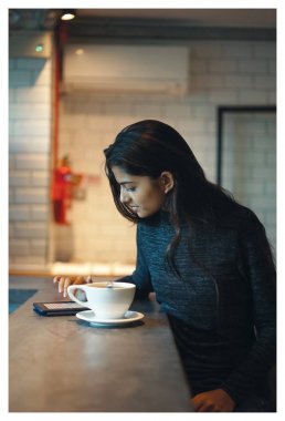 Bir genç, çekici ve zarif Hint Asya Bayan sıcak ve rahat bir kafede portresi. Doğal, rahat bir şekilde gülüyor.