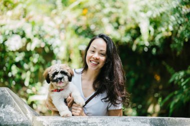 Parkta onun shih tzuh köpek olan bir genç, çekici pan Asya kadın portresi. Onlar ortasında bir yürüyüş ve neşeli ve rahat görünüyorlar.