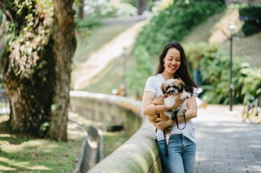 Parkta onun shih tzuh köpek olan bir genç, çekici pan Asya kadın portresi. Onlar ortasında bir yürüyüş ve neşeli ve rahat görünüyorlar.