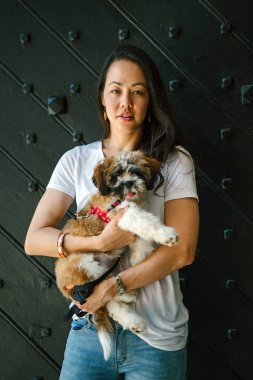 Onun köpeği ve yeşil bir parkta kamera için sıcak bir günde parkta gülümseyen genç bir Pan Asya kadın portresi. Köpek oyuncak doğurmak shih tzuh olduğunu.