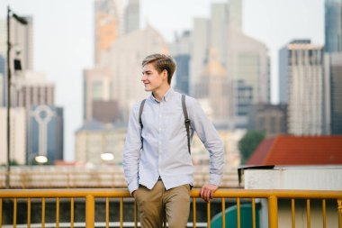 genç ve çekici beyaz bir portresi beyaz adam (turist veya öğrenci) gündoğumu veya günbatımı Asya'da gülümseyerek. O gülümsüyor ve rahat.