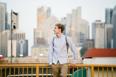 genç ve çekici beyaz bir portresi beyaz adam (turist veya öğrenci) gündoğumu veya günbatımı Asya'da gülümseyerek. O gülümsüyor ve rahat.