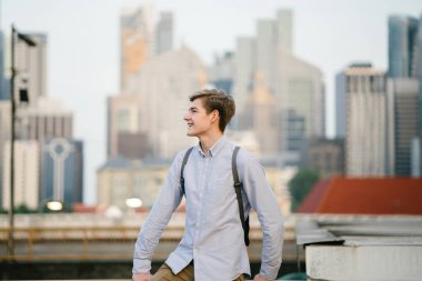 genç ve çekici beyaz bir portresi beyaz adam (turist veya öğrenci) gündoğumu veya günbatımı Asya'da gülümseyerek. O gülümsüyor ve rahat.