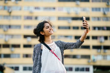 Sokaklarda telefonunu ile çekici ve genç Hintli Bayan turist portresi.