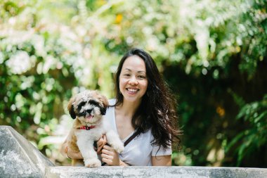 Parkta onun shih tzuh köpek olan bir genç, çekici pan Asya kadın portresi. Onlar ortasında bir yürüyüş ve neşeli ve rahat görünüyorlar.