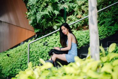 Bir genç, fotojenik ve çekici Çinli Asyalı kadın ile o günlerde Asya'da bir sokakta randevusu için beklediği sırada smartphone portresi. O gülümsüyor ve mutlu görünüyor.