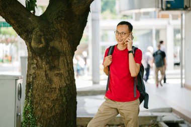 şehir içinde telefon olan orta yaşlı Asya adam