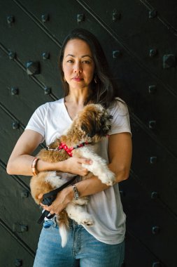 Onun köpeği ve yeşil bir parkta kamera için sıcak bir günde parkta gülümseyen genç bir Pan Asya kadın portresi. Köpek oyuncak doğurmak shih tzuh olduğunu.