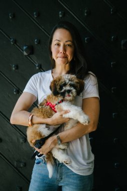 Genç bir kız ve köpeği portresi. Pan Asya kadın çekici ve raslantı giyimli ve onun Shih Tzuh onun kollarında taşıyor ve yumuşak gülümsüyor.