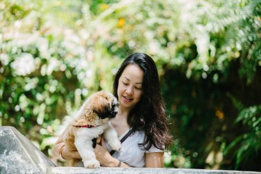 Parkta onun shih tzuh köpek olan bir genç, çekici pan Asya kadın portresi. Onlar ortasında bir yürüyüş ve neşeli ve rahat görünüyorlar.