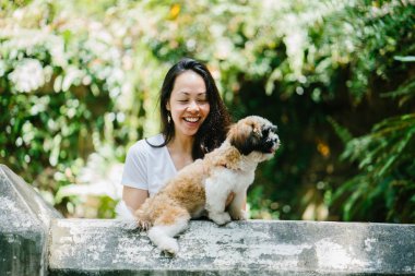Parkta onun shih tzuh köpek olan bir genç, çekici pan Asya kadın portresi. Onlar ortasında bir yürüyüş ve neşeli ve rahat görünüyorlar.