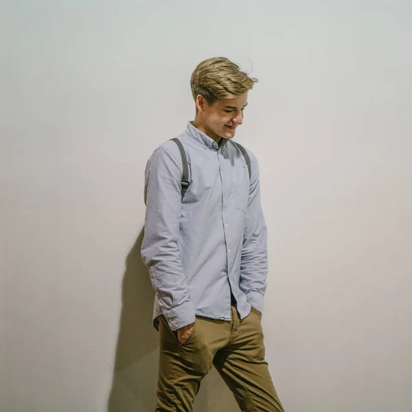 Candid portrait of a young attractive caucasian male standing and smiling. He in city  and  dressed casually yet smartly.