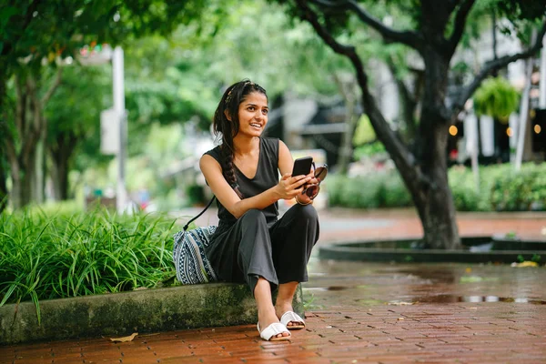 Портрет Молодой Азиатской Индийской Женщины Сидящей Парке Мобильным Телефоном Улыбающейся — стоковое фото