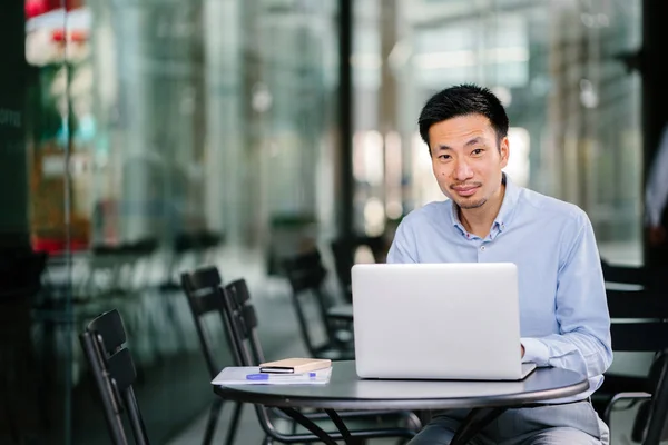 Professional head shot of a young professional (lawyer, banker, accountant, etc). He is smiling confidently in the day and professionally dressed in a shirt