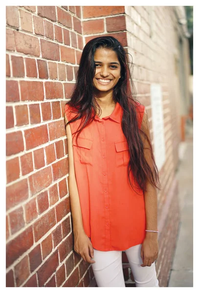 Infront 立っている若くて魅力的なインド アジア女性の肖像 レンガの壁の街の通りに 彼女は暖かい太陽の下で笑っています — ストック写真
