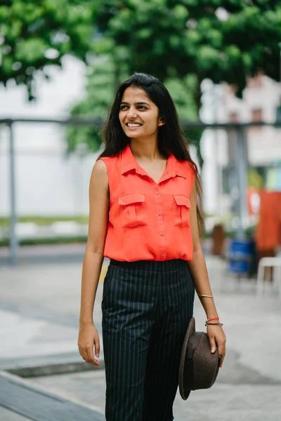 魅力的で若いインド アジアの女性は 太陽の下で通りに立っています 彼女は非常にファッショナブルな彼女の笑顔と茶色のフェドーラ帽を保持 — ストック写真